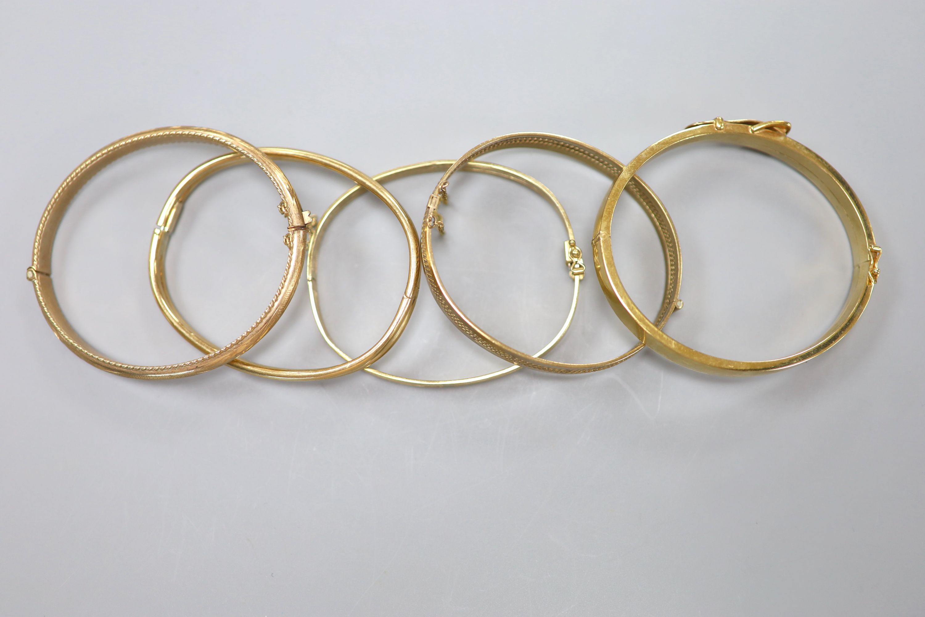 Five assorted modern 9ct gold hinged bangles